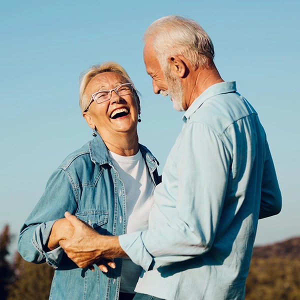 Senior couple dressed in blue holding hands and smiling