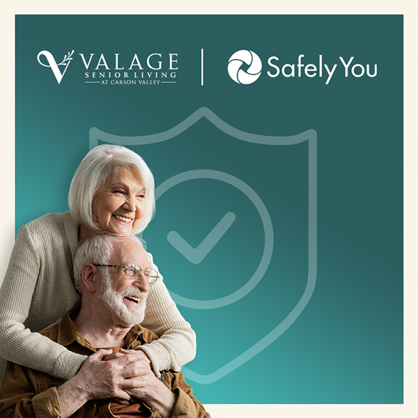 An elderly woman hugs an elderly man from behind while they both smile. Behind them is a large shield graphic. Logos for Valage Senior Living and SafelyYou appear at the top.